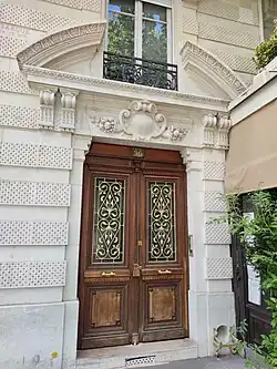 No&nbsp;96 : entrée surmontée d'un fronton cintré brisé.