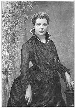 photographie noir et blanc : portrait en pied d'une femme en robe noire