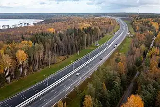 La route fédérale A181, en 2x3 voies, en vue aérienne, avec de chaque côtés des étendues de taïga aux couleurs automnales.