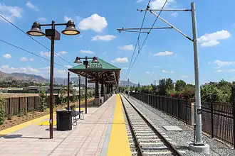 Surface podotactile de couleur jaune sur les bords de quai. Ciel bleu.