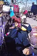 Vente personnelle: De jeunes vendeuses de bière avertissent le photographe qu'il doit également en acheter, marché de Tireli , Mali 1989