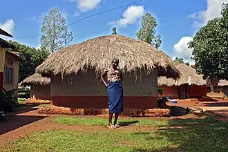 Une femme devant sa maison.
