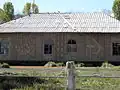 Vue d'une maison (sans doute un ancien club communal) avec les symboles du communisme soviétique