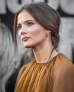 Une femme aux yeux bleus et aux cheveux châtains.