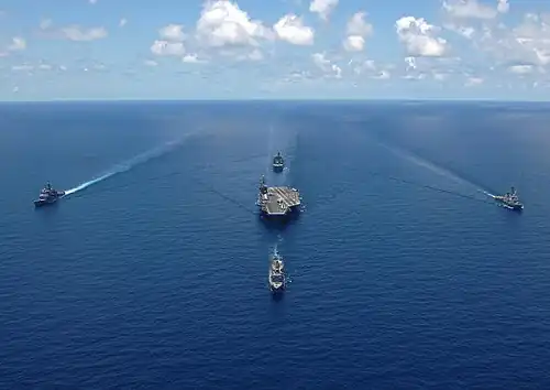 Le George Washington en formation avec 4 navires d'escorte, en haute mer.