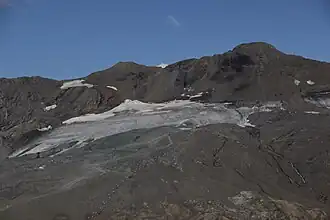 Vue de l'aiguille Pers (au centre), de la pointe Pers (à gauche), de la pointe du Montet (à droite) dominant le glacier du Grand Pisaillas et le domaine de ski d'été de Val-d'Isère depuis le col de l'Iseran à l'ouest.