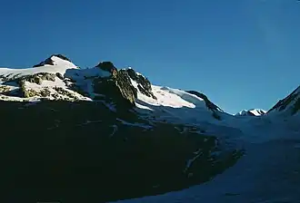L'aiguille de la Bérangère et son glacier au soleil sur la gauche dominant le glacier de Tré-la-Tête dans l'ombre sur la droite de l'autre côté de la pointe des Conscrits.