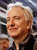 Portrait d'Alan Rickman pris après sa performance lors d'un séminaire au John Golden Theater, à New York, le 10 novembre 2011. Cette photographie a été retouchée et montre l'acteur en gros plan, vêtu d'un costume sombre, avec une expression sérieuse. L'image a été réalisée par Marie-Lan Nguyen.