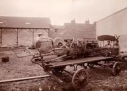 Photo des restes d'une voiture accidentée posée sur un plateau roulant.