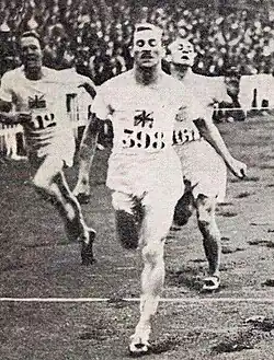 Photo d'un homme passant une ligne d'arrivée, à ses côtés ses concurrents.