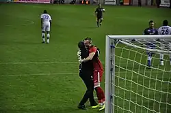 Entraîneur adjoint congratulant son gardien de but.