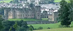 Vue du château d’Alnwick, forteresse médiévale située dans le Northumberland, en Angleterre, avec ses tours crénelées et ses remparts en pierre.