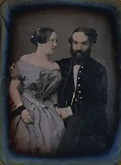 le compositeur, de face, tient de la main gauche la main droite de la jeune femme placée à sa droite et qui le regarde, tandis qu'il l'enlace du bras droit.