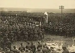 Photographie noir et blanc montrant une foule et l'aumônier au centre.
