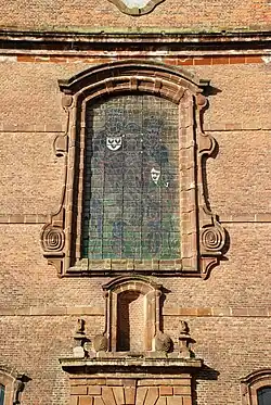 La verrière ornée de volutes baroques.