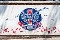 Une fresque antiaméricaine devant l'ancienne ambassade, détournant le grand sceau des États-Unis.