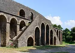 Vue d'un escalier double plaqué contre la façade d'un amphithéâtre.