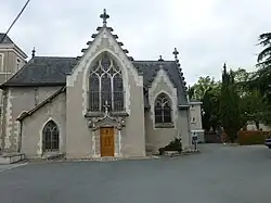 Photographie d'une petite chapelle à pignons, crépi à dominante gris-beige.