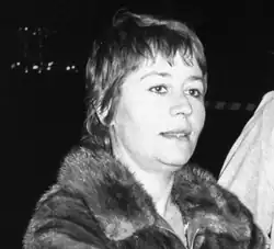 Une femme aux cheveux courts dans une veste de fourrure.