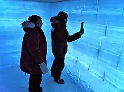 Grotte de glace dans une ambiance bleue et blanche présentant une stratification de la glace.