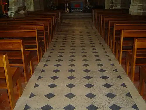 Le pavement de la nef. À gauche et à droite figure le pavement ancien en brique de Beauvais.