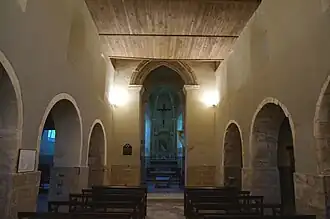 La nef, arcades de plein-cintre des bas-côtés, arcs brisés à la tour et au chœur.