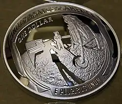 Pièce de monnaie en argent avec un astronaute, le drapeau américain et le module lunaire gravés.