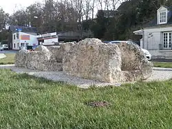 Vue d'un vestige de monument antique (canal d'aqueduc) exposé au milieu d'une pelouse.