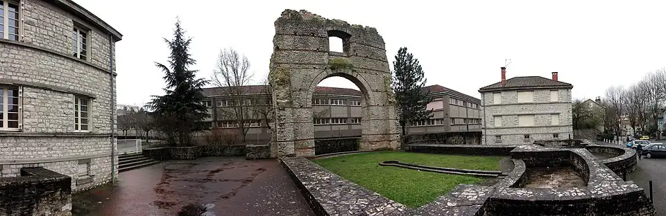 Vue générale des vestiges des thermes ; frigidarium engazonné au centre.