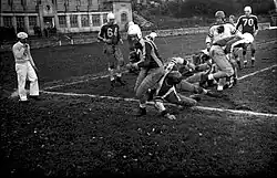 Action de jeu: un joueur portant le ballon tente d'échapper à un plaquage