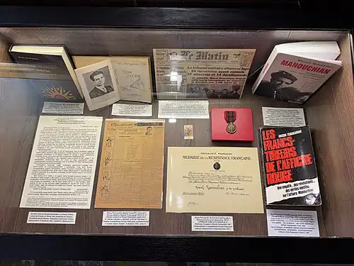 Photographie d'une vitrine où l'on peut voir des ouvrages et des documents.