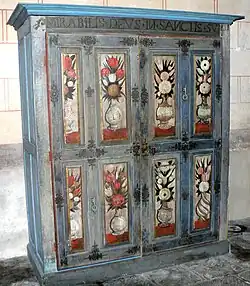 Armoire à reliquaires décorée de clés et de fleurs de lys.