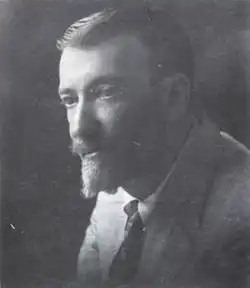 Photo en noir et blanc montrant un homme avec une moustache et un bouc