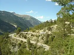 Photo des lacets sur les flancs d'une montagne couverte d'arbres.