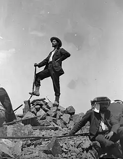 Photographie en noir et blanc d'un homme au sommet d'une montagne.
