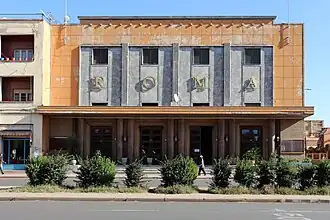 Photographie d'un cinéma de style moderniste enduit d'orange.