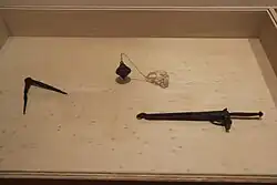 Trois outils dont un compas présentés dans une vitrine.