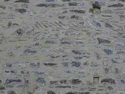 Rétablissement d'une horizontalité dans un mur en moellons irréguliers.