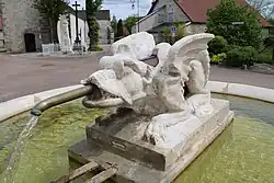 Sa tête de dragon crache l'eau de la fontaine.