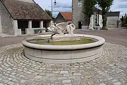 La fontaine de la Peûte Bête au centre de la place.
