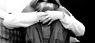 Photo noir et blanc d'une fille avec la tête entre les genoux