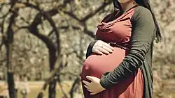 Photo de ventre d'une femme enceinte en automne