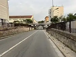 Viaduc de la Ligne de La Plaine à Ermont - Eaubonne et ancienne Usine PSA de Saint-Ouen (au fond à gauche) en juin 2022.
