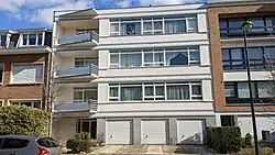 Au n° 59, un immeuble à appartements du style moderniste caractéristique de 1957, de quatre niveaux et deux travées inégales sous toit plat, construit en 1957 par l'architecte M. J. Schmidt