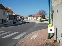 L'avenue de la mairie. La borne kilométrique au premier plan montre l'appartenance à la voirie départementale de cette rue.