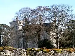 Vue générale d'un bâtiment flanqué d'une tour carrée couronnée de créneaux.