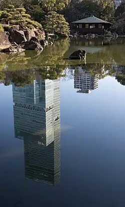 L'Abeno Harukas se reflète dans l’étang du jardin, à proximité d'un gazébo.