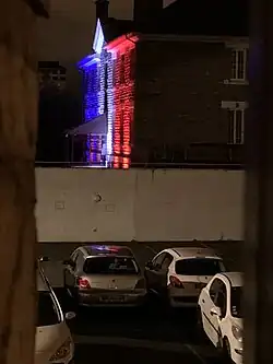 Bâtiment de la caserne Guillaudot illuminée du drapeau tricolore.