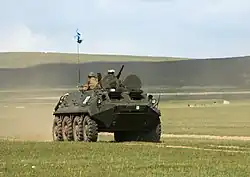 Photo représentant un véhicule de combat dans une plaine de Mongolie, participant aux exercices militaires dans le cadre de Khaan Quest