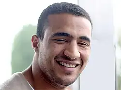 Portrait d'un homme souriant, les yeux fermés.